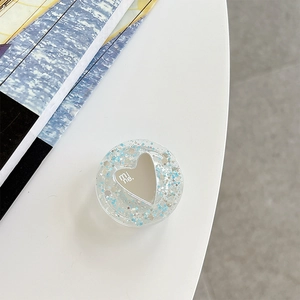 Detail of heart-shaped mirror phone grip with blue glitter and 'mi ne' text