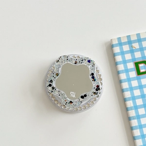 Macro shot of circular phone grip with sparkling glitter, crystal rim and built-in mirror
