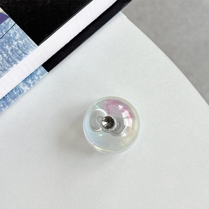 Macro detail of iridescent crystal ball phone grip with a silver metal bow and diamond