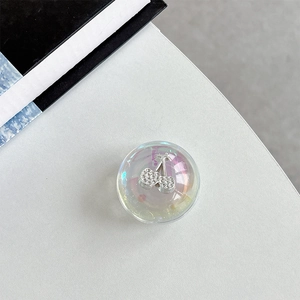 Macro shot of iridescent resin phone grip featuring a crystal-embedded cherry design