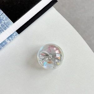 Macro shot of circular resin phone grip with 3D silver bow and iridescent aurora finish