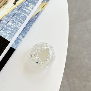 Detail of heart mirror phone grip with silver glitter and 'mi ne' text on acrylic