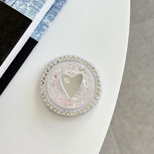 Macro shot of phone grip featuring silver heart mirror, rhinestones, and pink glitter
