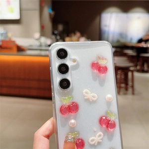 Detailed view of 3D cherry and pearl bow ornaments on a glitter Samsung Galaxy case