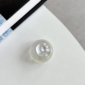 Macro detail of iridescent heart phone grip with sparkling crystal and embossed MIU logo