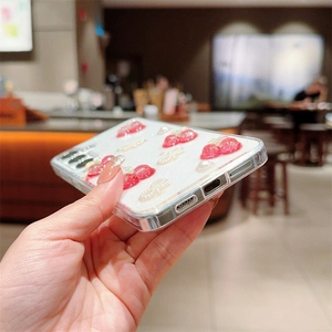 Close-up of clear phone case with 3D resin cherries, white bow, and pearls detail