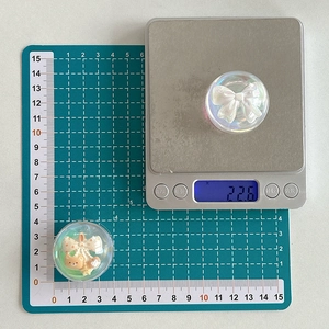 Macro detail of 3D resin crystal ball phone grip showing internal bow and bear design