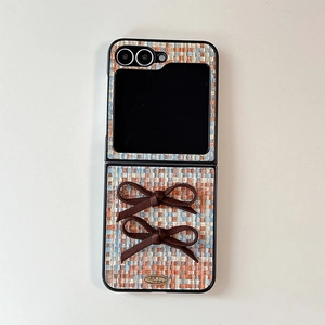 Detail of woven texture phone case with silk bows and gold metal Love is forever plate
