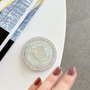Macro detail of round phone grip with iridescent sequins, rhinestones, and heart mirror