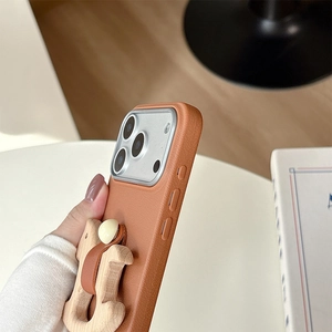 Close-up of brown leather phone case featuring a wooden H-shaped ring holder stand