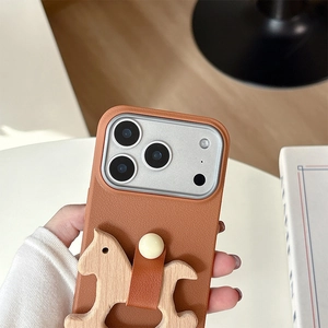 Detail of lychee textured leather iPhone case with a wooden rocking horse ornament