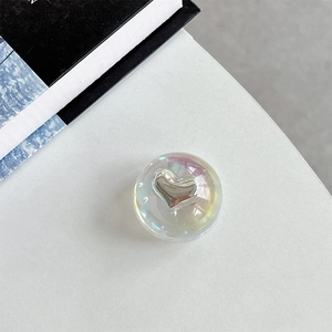 Macro detail of iridescent crystal ball phone grip with metallic heart design