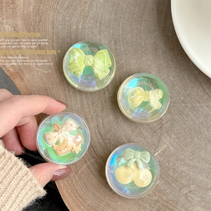 Close-up of iridescent crystal ball phone sockets with 3D bow and bear designs