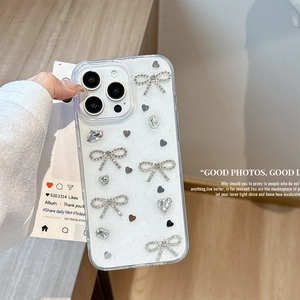 Gros plan sur une coque iPhone transparente pailletée avec nœuds strass 3D et cœurs