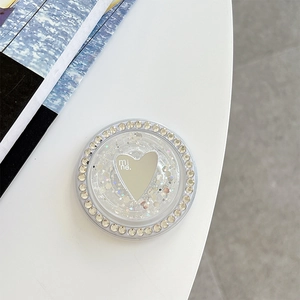 Detail of a sparkling rhinestone phone grip with a heart mirror and mine lettering