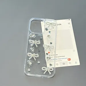 Détail de la coque iPhone transparente ornée de nœuds en strass argentés et de cœurs