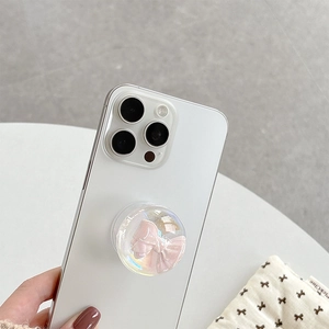 Pink 3D bow crystal ball phone grip stand mounted on a white smartphone