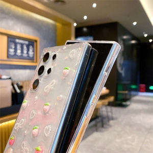 Side view of clear glitter Samsung case with 3D strawberry and bow decorations