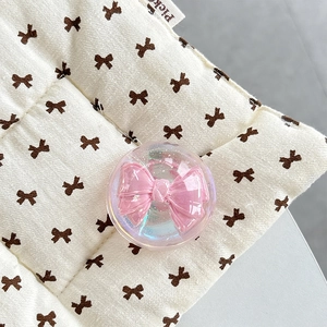 Macro shot of iridescent resin phone grip featuring a 3D pink bow inlay decoration