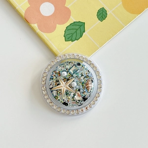 Detailed view of ocean theme phone socket with starfish, shells and glitter accents