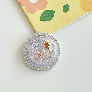 Detail of purple glitter phone grip with starfish, seashells and pearl decorations