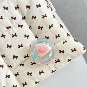 Close-up of holographic crystal ball phone grip with pink bow and cake design