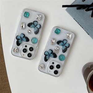 Luxe iPhone case with blue butterflies and sparkling rhinestones on clear cover
