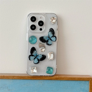 Detail of transparent iPhone case with blue glitter butterflies and sparkly rhinestones