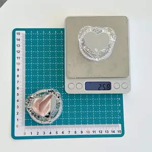 Détail du support de téléphone cœur sur balance avec paillettes et miroir intégré