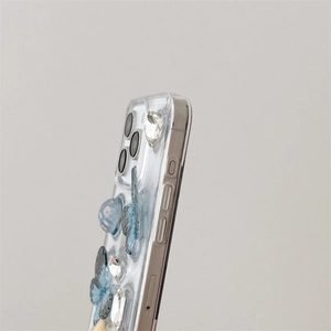 Detail of 3D gradient blue butterfly and rhinestone accents on transparent phone case