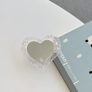 Détail du support MagSafe cœur pailleté avec miroir et logo mine gravé