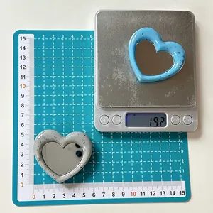 Detail showing heart mirror phone stand dimensions on scale and measuring mat