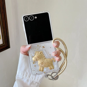 Détail de la coque Z Flip transparente avec breloque poney doré et feuilles d'or