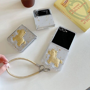 Détail de coque Samsung Z Flip avec feuille d'or, breloque cheval et dragonne en cuir
