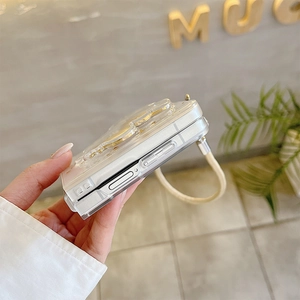 Détail de la coque Galaxy Z Flip avec ours 3D doré et cordon de transport tressé