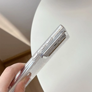 Detail view of transparent glitter case with raised metal camera protection and precise cutouts