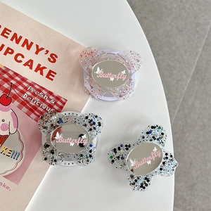 Close-up of butterfly phone grips with glitter filling and integrated makeup mirror