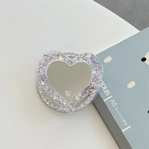 Détail macro du support Magsafe en forme de cœur avec paillettes violettes et miroir