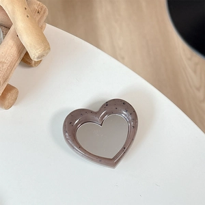 Detail of heart-shaped phone grip with gray-purple stone texture and built-in makeup mirror