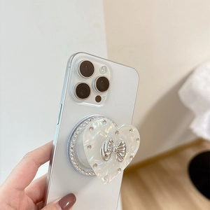 Macro view of heart-shaped phone grip with mother-of-pearl finish and bow detail