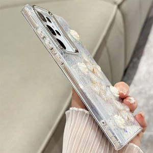 Detailed 45-degree view of a clear glitter phone case with 3D pearl flowers and butterflies