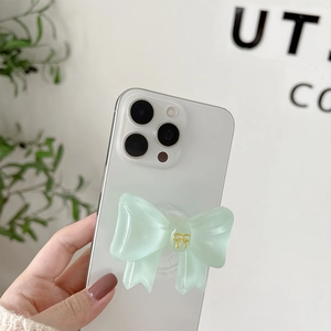 Detail of mint green bow phone grip with golden engraving on white mobile back