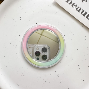 Close-up of circular Magsafe mirror phone grip with pastel pink and yellow gradient frame