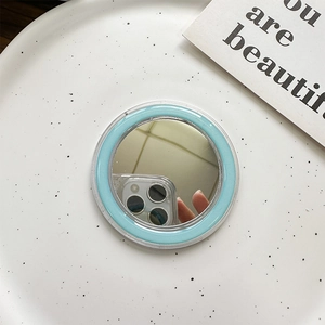 Detail of light blue MagSafe mirror accessory on a white tray with aesthetic card