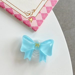 Macro view of light blue jelly resin bow phone grip with a golden metal ornament