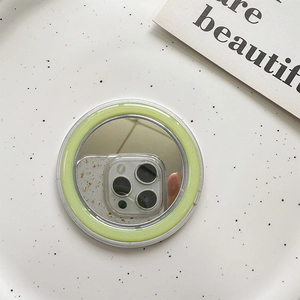 Detail of a round light green Magsafe mirror phone socket with a highly reflective surface
