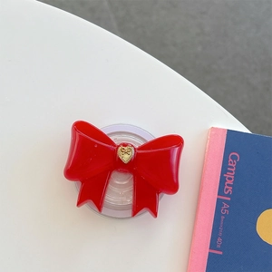 Dettaglio del supporto per telefono a forma di fiocco rosso con cuore d'oro inciso