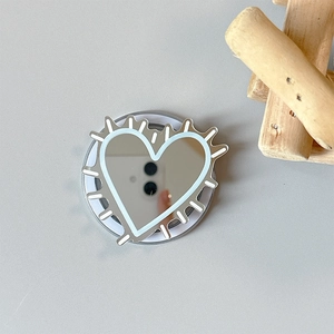 Detail view of heart-shaped mirror phone grip with blue outlines on a blue-grey background