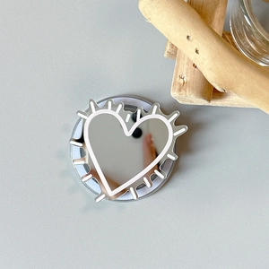 Macro view of heart-shaped silver mirror phone grip with white thorn line art