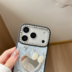 Detail of blue snakeskin texture phone case with heart mirror and rhinestone bow